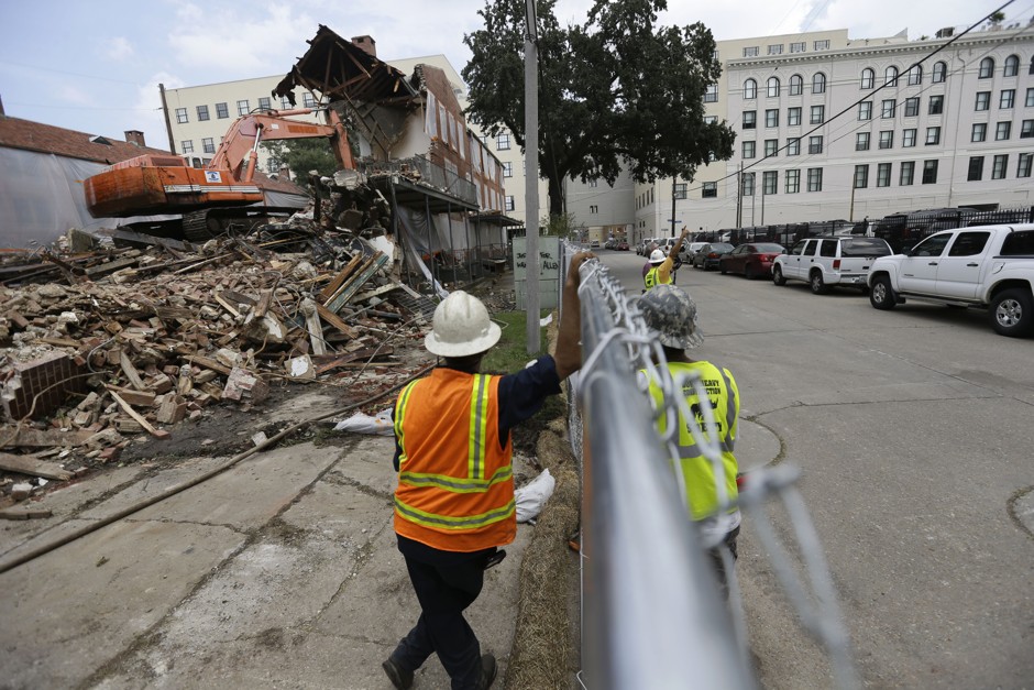 Workers watch as cranes take down units of the Iberville housing projects in New Orleans.