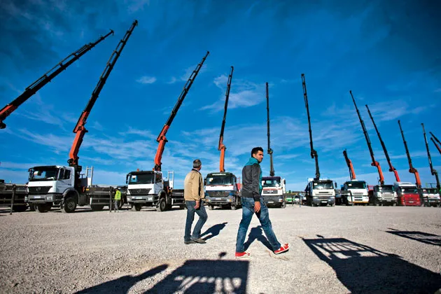 Potential buyers inspect and bid on new and used construction equipment at an auction in Ocaña, Spain