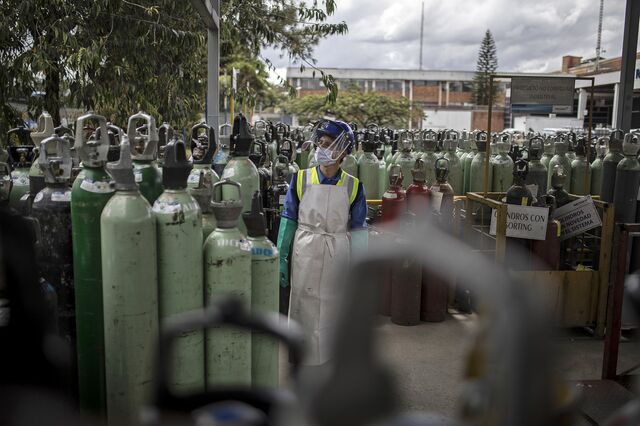 A worker wearing a protective mask and face shield checks the quality of oxygen tanks at the Messer Group medical oxygen production facility in Bogota, Colombia, on Monday, Feb. 1, 2021. Several neighborhoods in Colombia's capital will be placed under lockdown starting Saturday, affecting roughly 1.5 million residents, as hospital ICU beds remain more than 90% full.