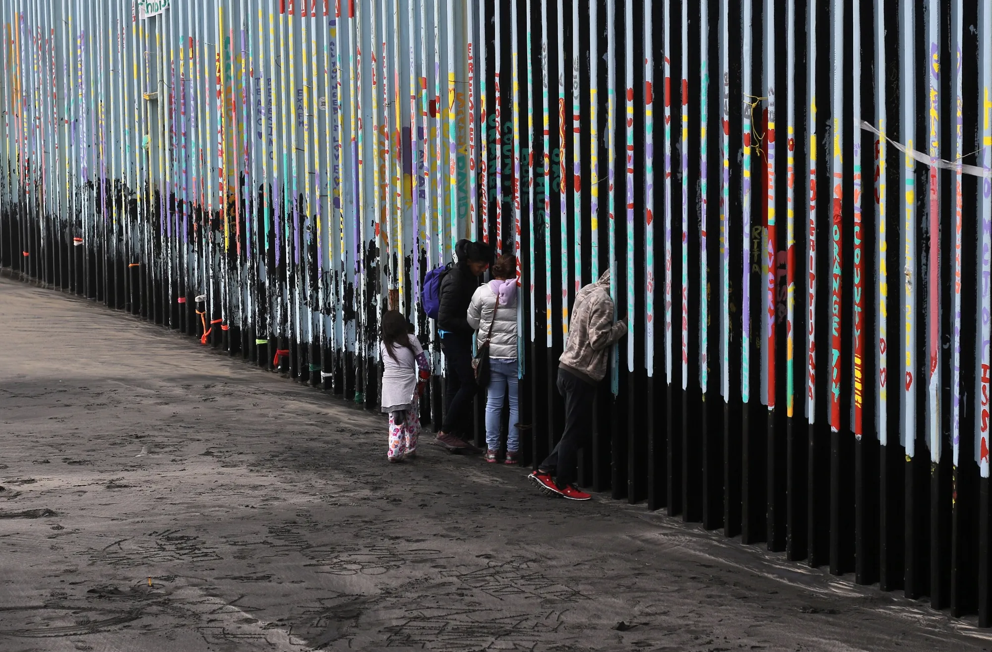 A family looks through the US-Mexico border fence,&nbsp;from Playas de Tijuana, in Baja California state, Mexico.