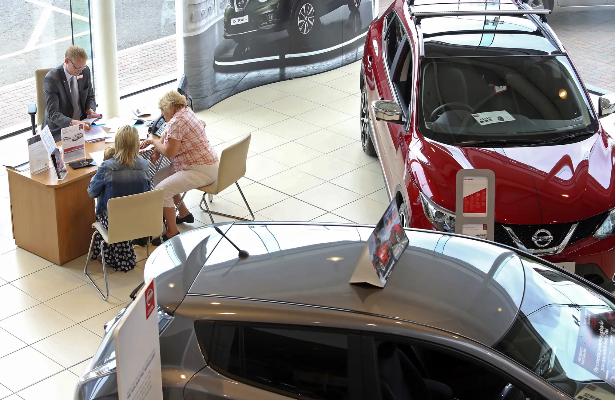 A salesman talks to customers at a car dealership in Rochford, U.K.
