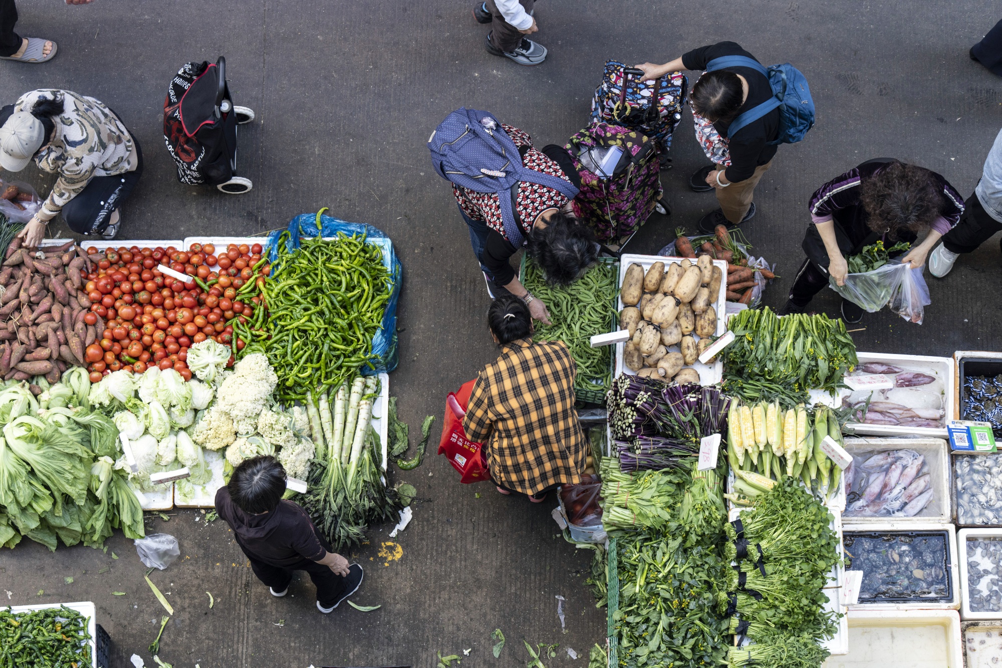 Customers shop vegetables at a market in Shenzhen, China.