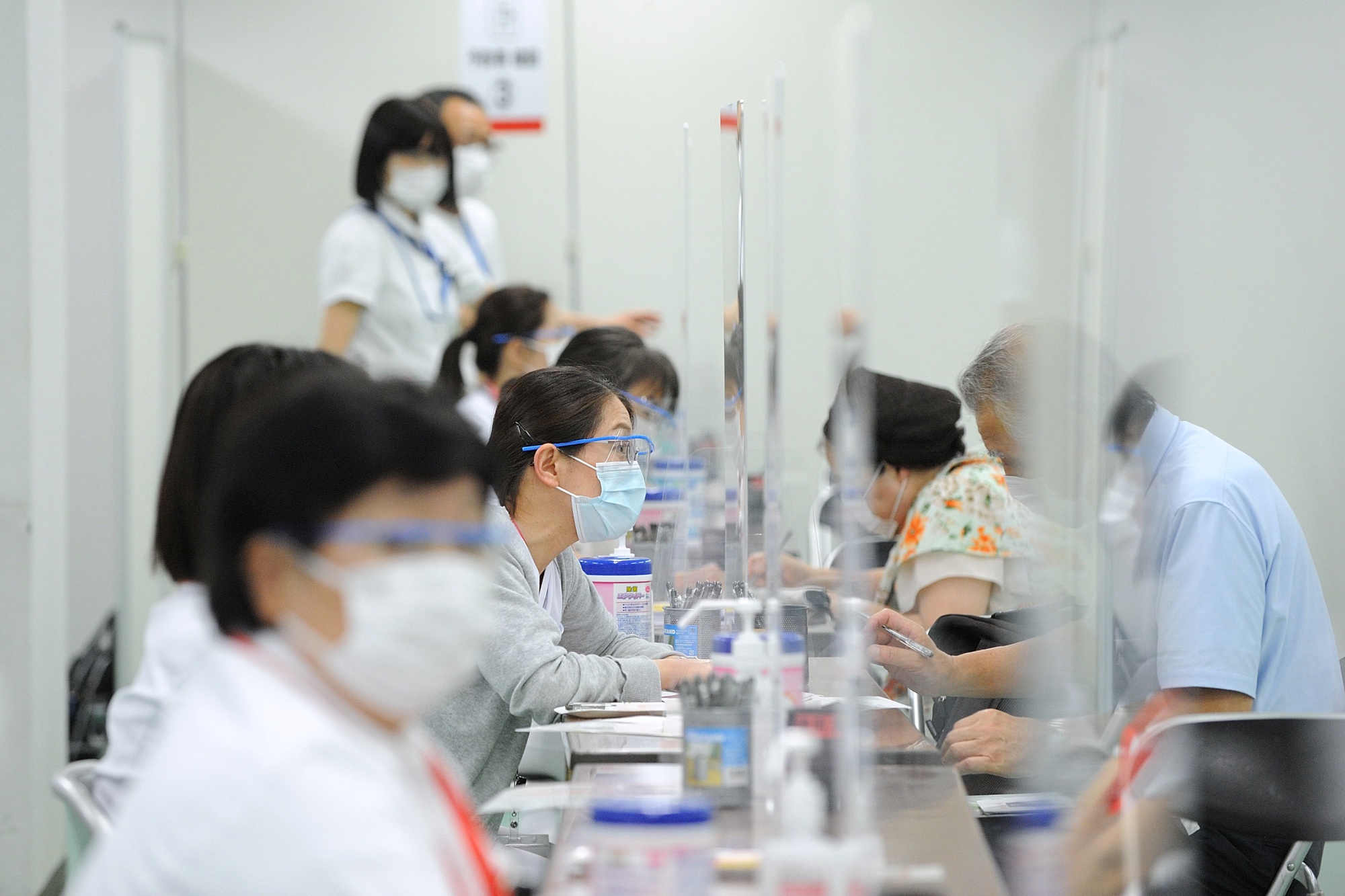 Mediacal workers consult with people at a mass vaccination site in Tokyo, June 9.