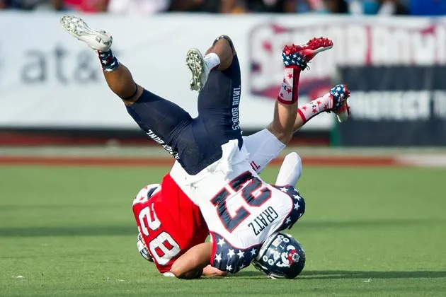 Defensive back Dwayne Gratz #27 (Connecticut) lands on his head while tackling wide receiver Conner Vernon #82 (Duke) during the 2013 Senior Bowl.


