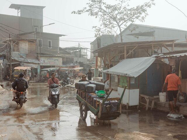 A water seller pushes his carriage toward a refill station in Muara Angke, North Jakarta. Photographer: Muhammad Fadli