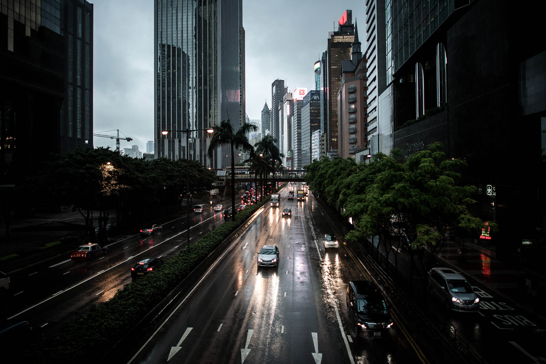 Cars are seen using headlights during the day as a storm pummels Hong Kong. Gross domestic product contracted 0.4 percent in the three months through March from the previous quarter, the government said in a statement Friday.
