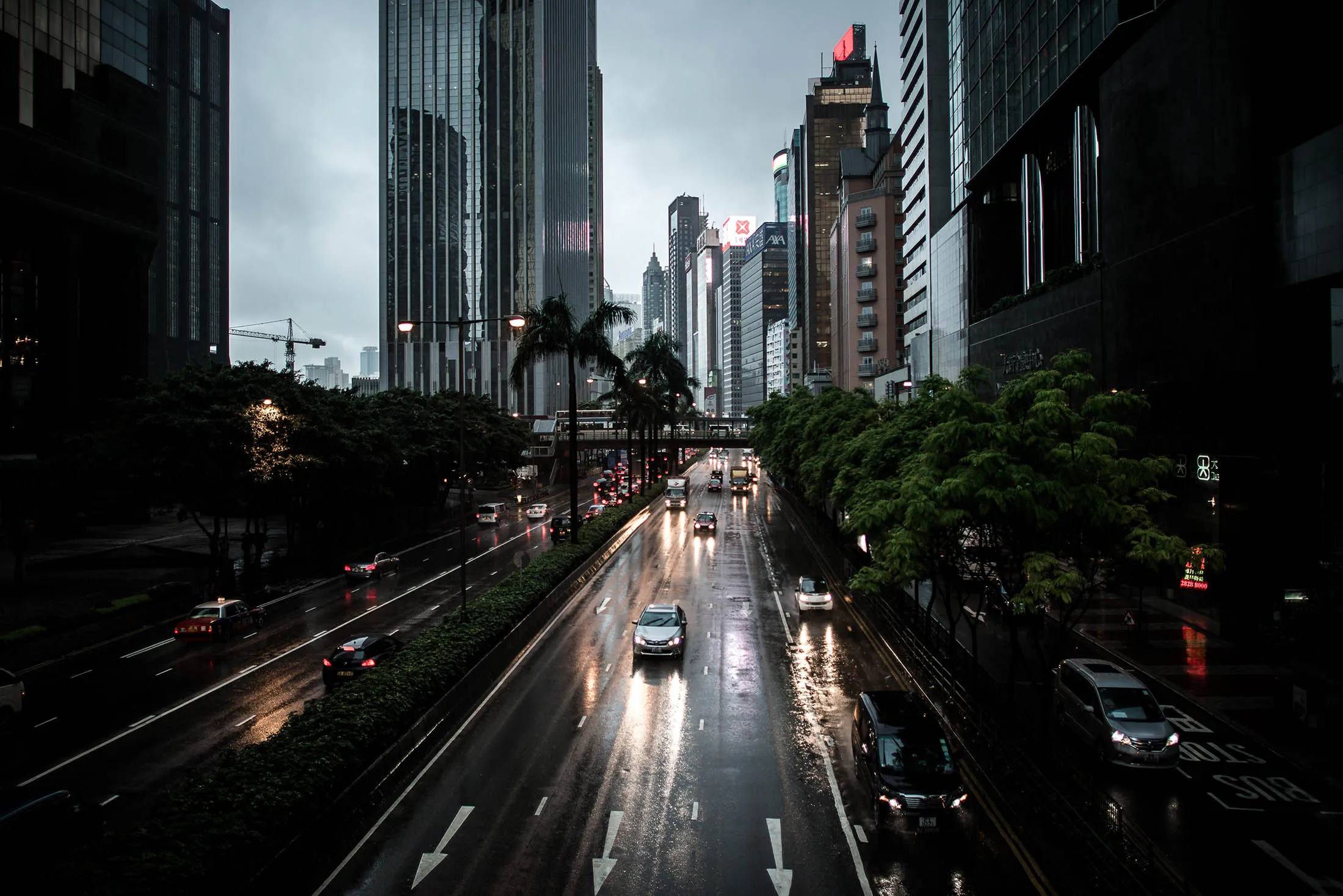 Cars are seen using headlights during the day as a storm pummels Hong Kong. Gross domestic product contracted 0.4 percent in the three months through March from the previous quarter, the government said in a statement Friday.
