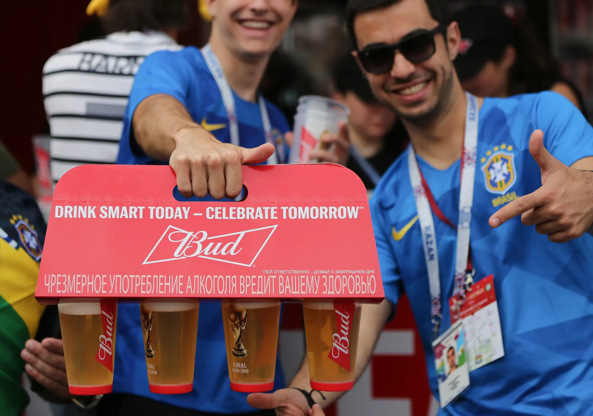Supporters display a case of Bud beer, manufactured by Anheuser-Busch InBev SA, as they pose outside Luzhniki Stadium ahead of the FIFA World Cup final match in Moscow, Russia, on Sunday, July 15, 2018.