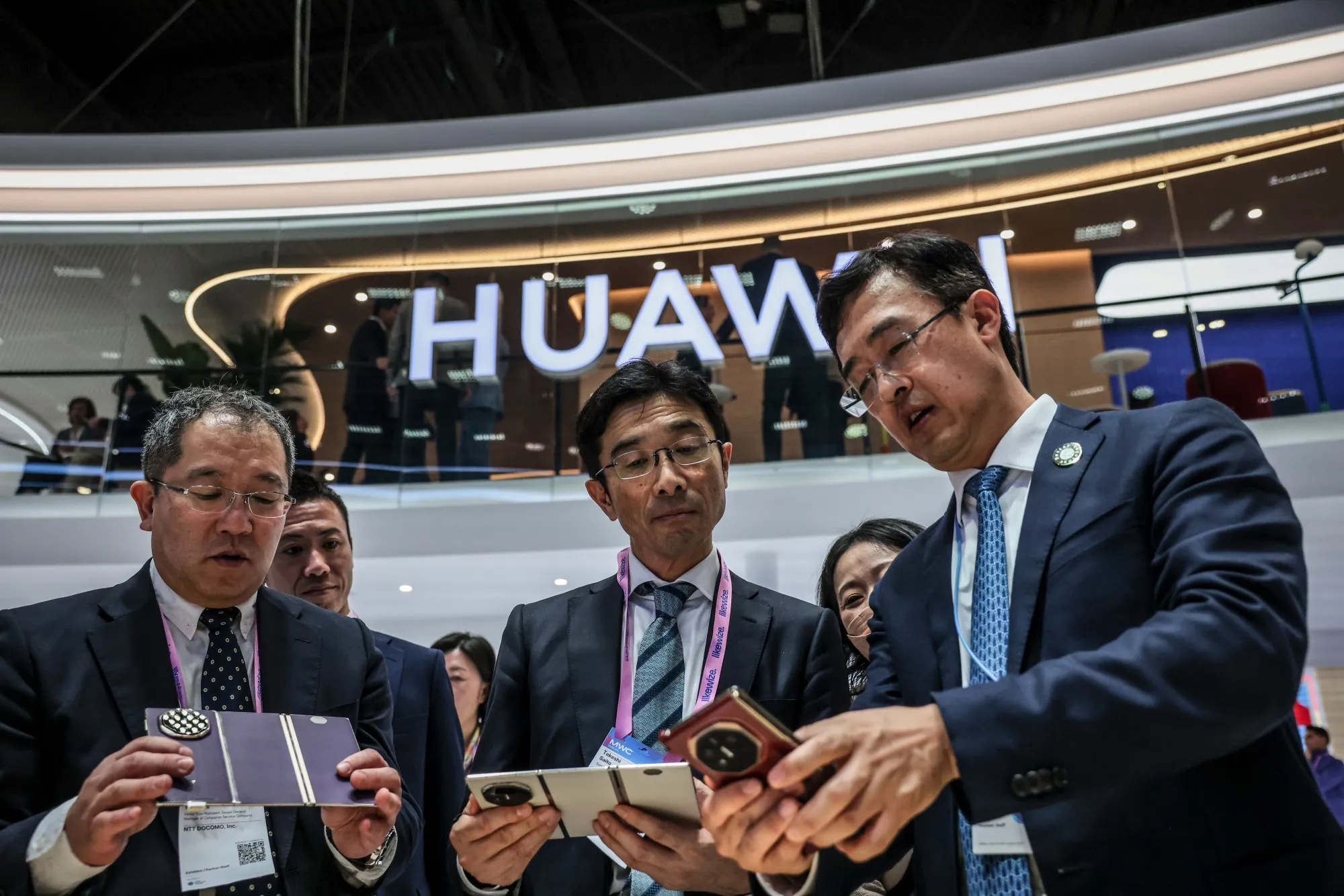 Attendees inspect Huawei Mate XT trifold smartphones on March 3 at MWC Barcelona 2026.