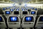 Screens are illuminated in the economy-class cabin on board an American Airlines Group Inc. Boeing Co. 777-300ER aircraft at Hong Kong International Airport in Hong Kong, China, on Friday, June 13, 2014.
