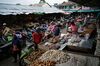A fishmonger, center right, serves a customer as shoppers walk past vendors at stalls in Kapuas Hulu, West Kalimantan, Indonesia, on Friday, May 4, 2018. Indonesia has been one of the hardest hit economies in Asia amid a global selloff, with investors dumping almost $1.9 billion of government bonds since the end of March.