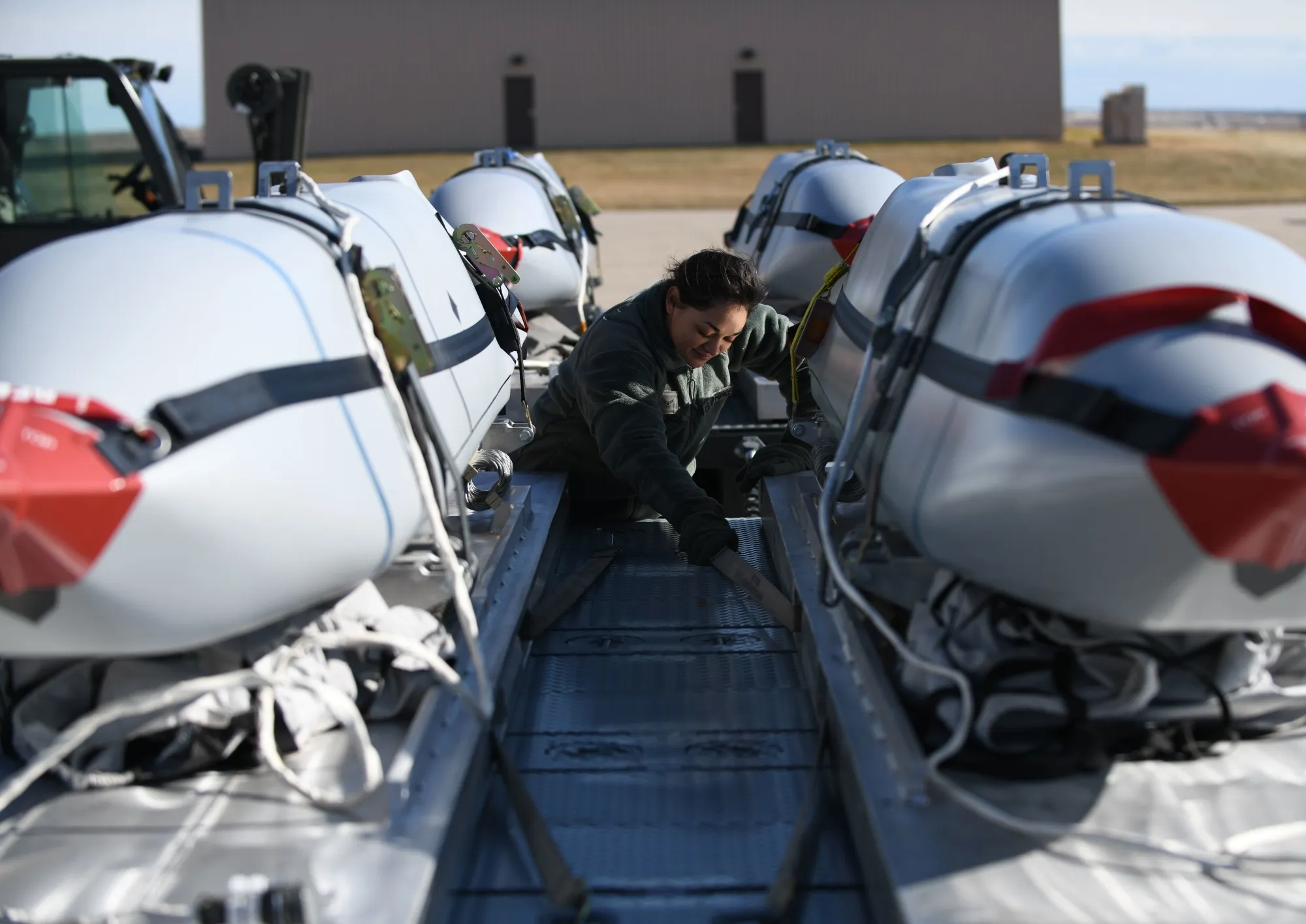 An airman from the 28th Munitions Squadron secures Joint Air-Surface Standoff Missiles (JASSM) on a flatbed truck at Ellsworth Air Force Base in Box Elder, South Dakota.