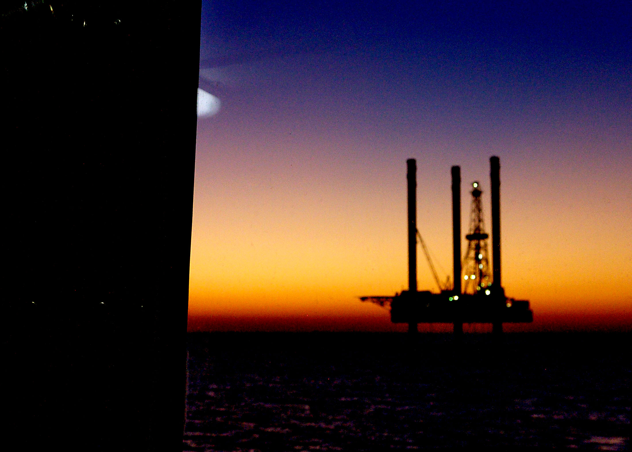 Silhouette of an offshore oil and gas jack up drilling at sunset