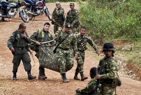 Colombian soldiers carry equipment of one of ten soldiers killed by the Revolutionary Armed Forces of Colombia (FARC) guerrillas, in the rural area of Buenos Aires, department of Cauca, Colombia.