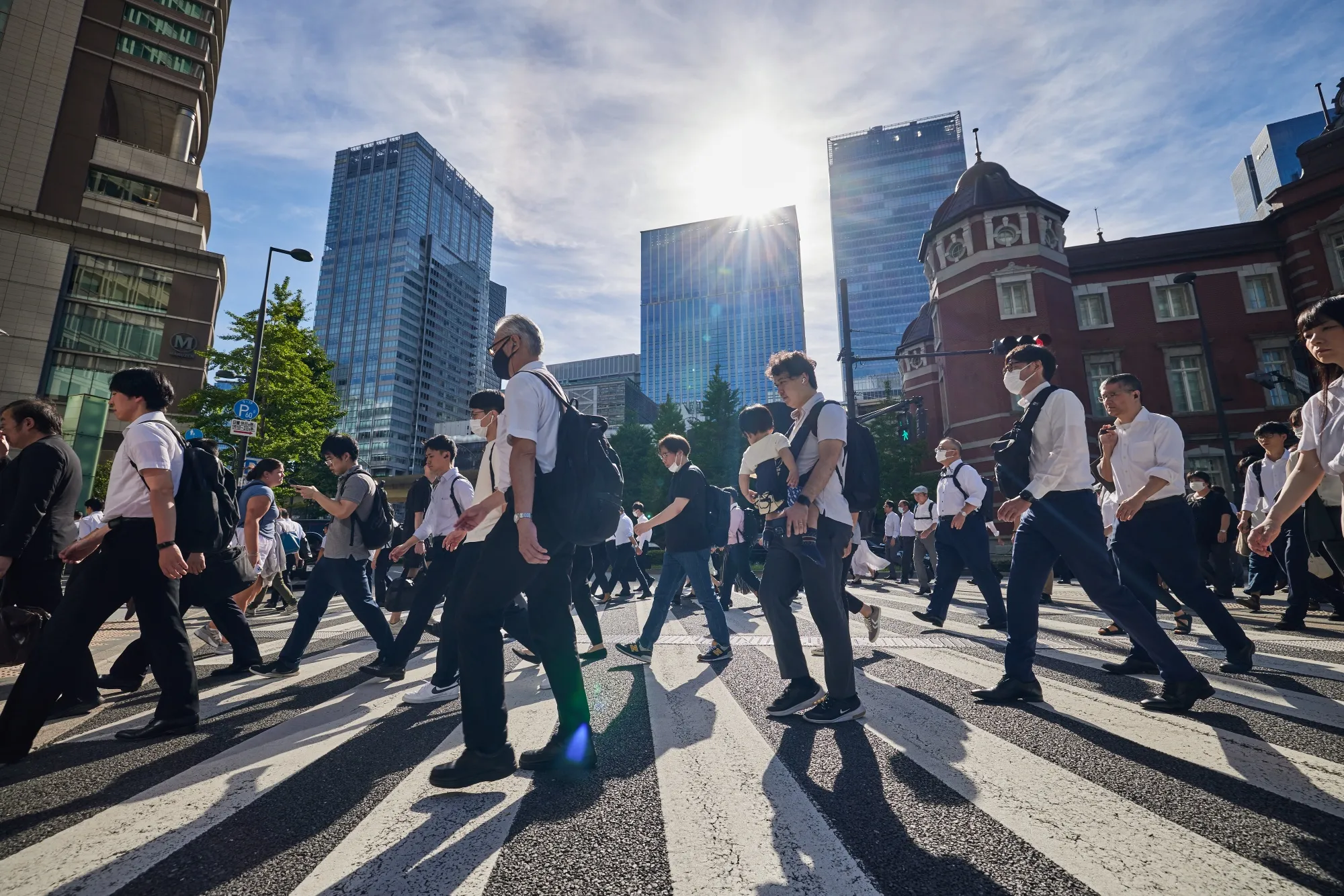 Morning commuters cross a street outside Tokyo Station in Tokyo, Japan.