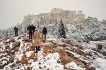 People take photos of The Parthenon temple atop the Acropolis&nbsp;during heavy snowfall &nbsp;in Athens on Jan. 24.