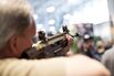 An man&nbsp;sights a rifle in a Remington exhibition booth.