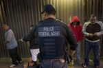 A U.S. Immigration and Customs Enforcement (ICE) agent directs a group of undocumented men being deported to Mexico at the U.S.-Mexico border in San Diego, California, on&nbsp;Feb. 26, 2015.