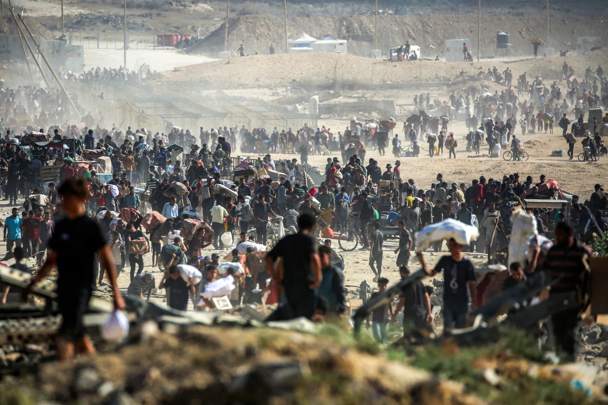 Palestinians carry humanitarian aid received from a distribution center in Nuseirat, Gaza, on Sept. 30.