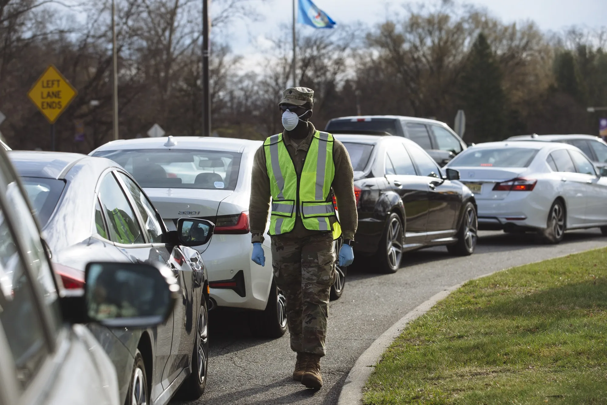A member of the New Jersey Army National Guard watches as people wait in their vehicles at a drive-through coronavirus testing facility in New Jersey, March 21.