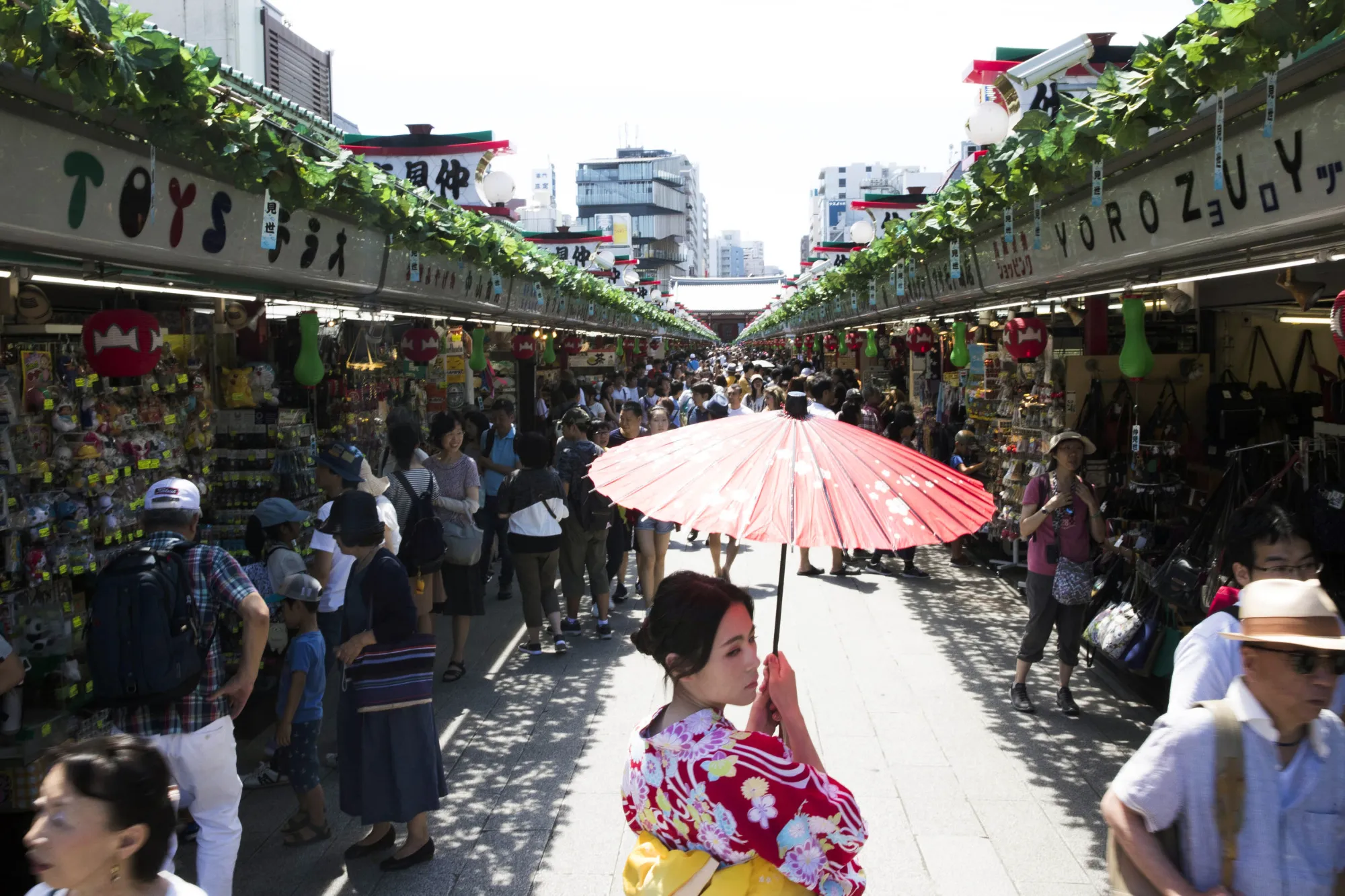 A woman dressed in a yukata walk past souvenir shops in Asakusa,&nbsp;Tokyo.