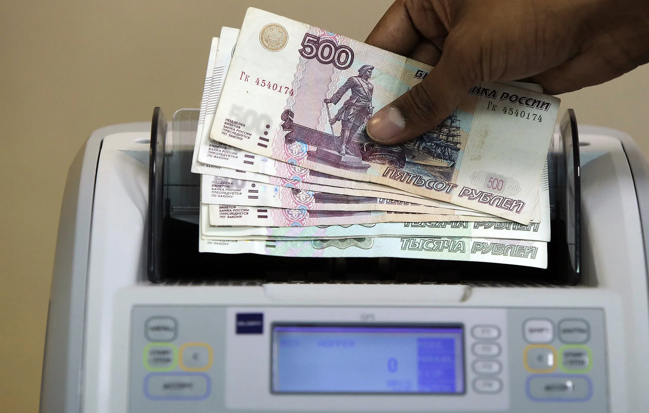 An employee loads Russian 500 ruble denomination banknotes into a counting machine at the Thomas Exchange Global Ltd. foreign currency exchange in London on Dec. 17, 2014.
