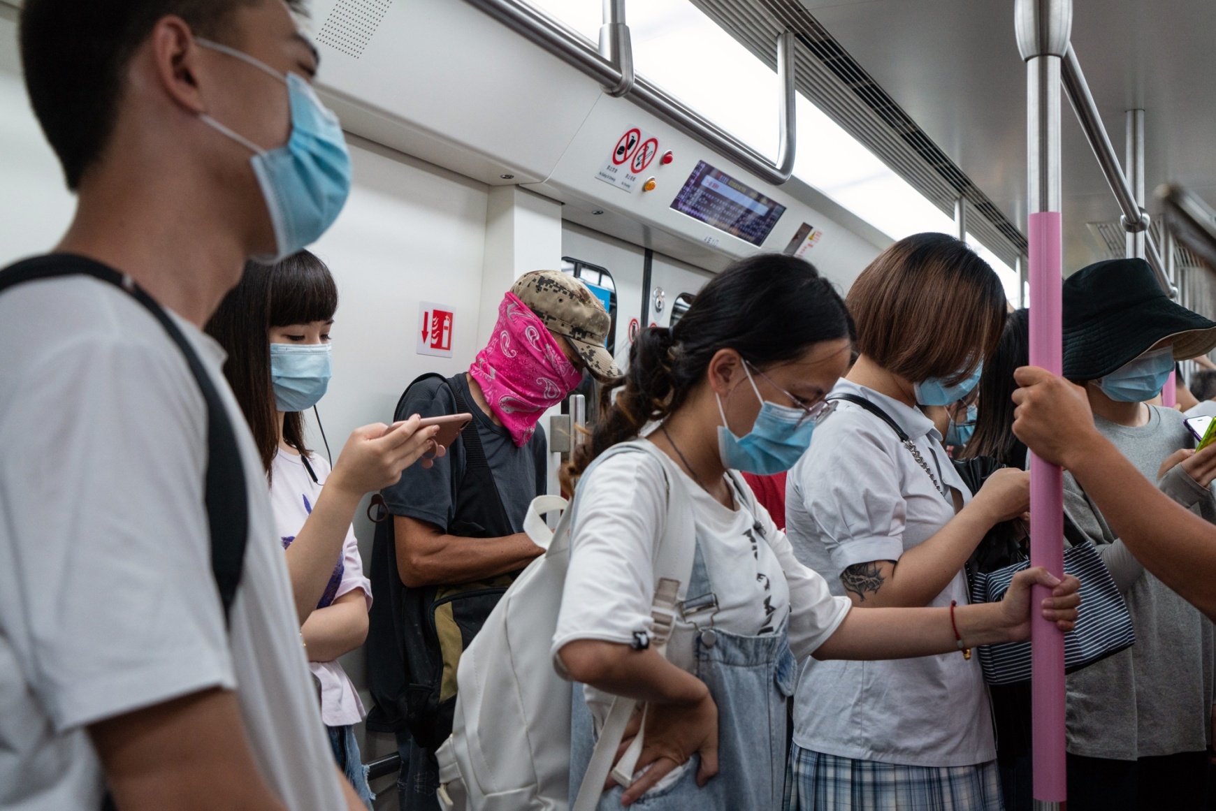 Commuters wear masks and face coverings on a busy subway train in Wuhan.