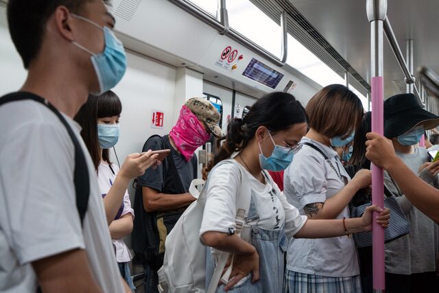Commuters wear masks and face coverings on a busy subway train in Wuhan.