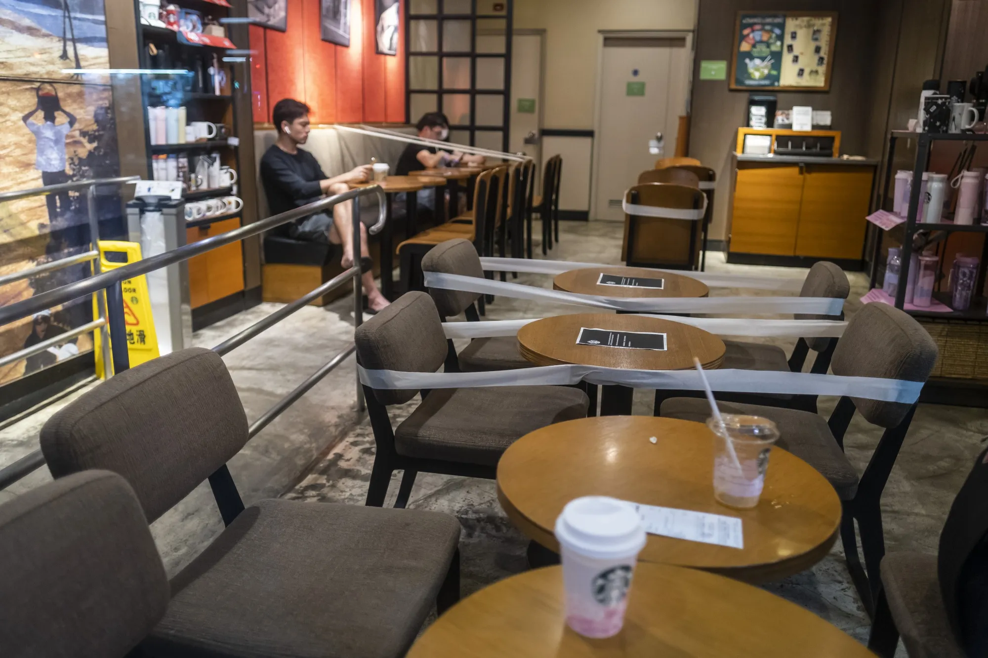 Tables are taped off to enforce social distancing at a Starbucks in Hong Kong on March 28, 2020.