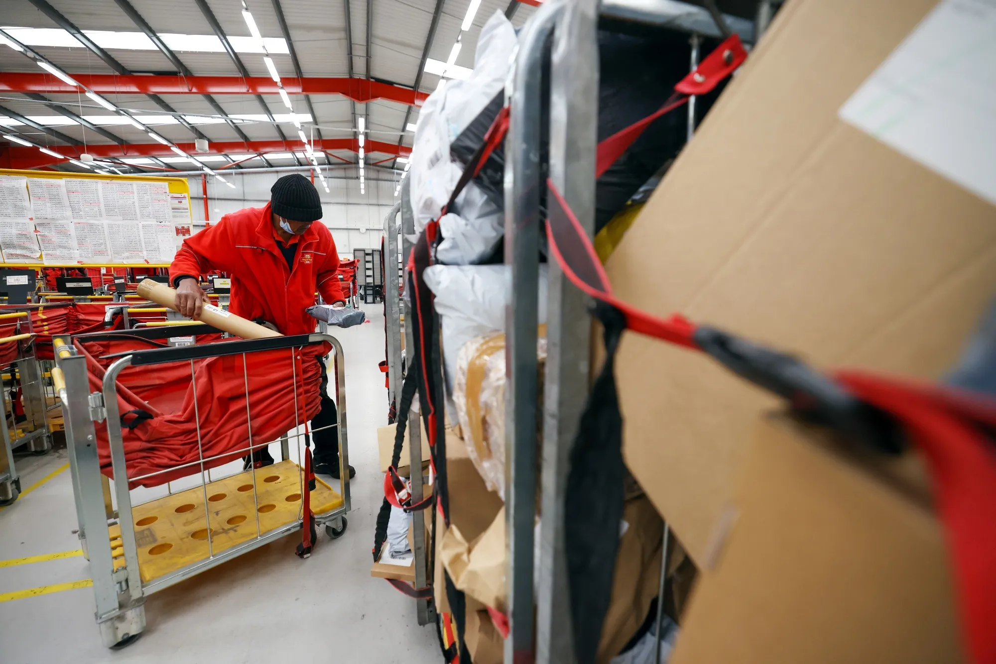 An employee sorts through a trolley of parcels the Royal Mail Plc sorting office in Chelmsford, U.K.
