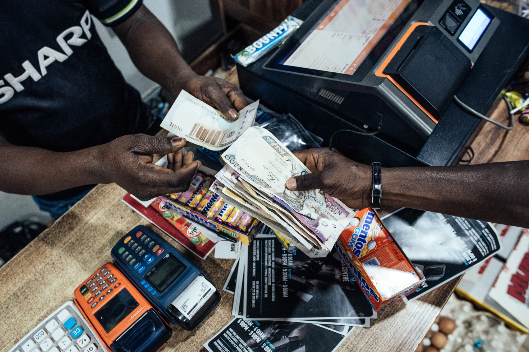 A customer hands over Nigerian naira banknotes in a store in Abuja.