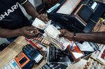 A customer hands over Nigerian naira banknotes in a store in Abuja.