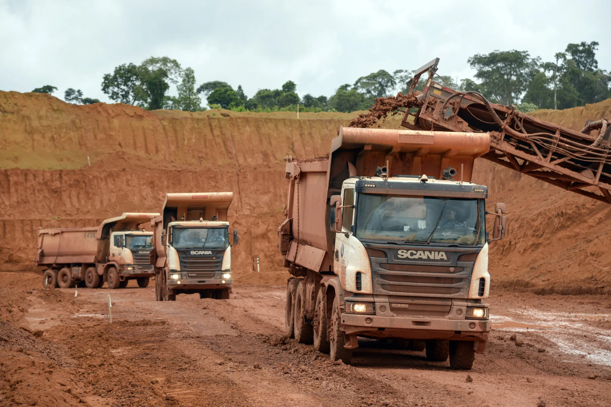Trucks are loaded with clay soil containing bauxite in the quarry at a&nbsp;bauxite mine in Paragominas, Brazil.