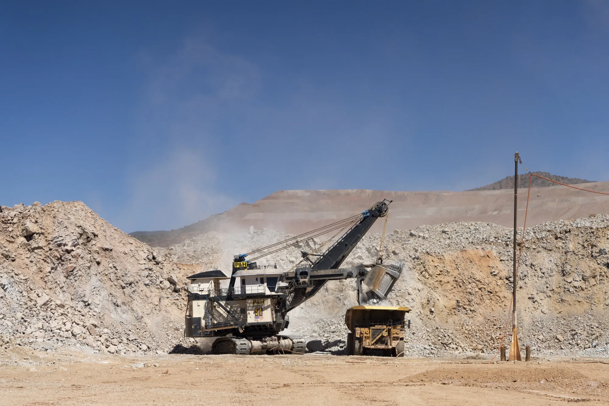 Ore and waste materials are loaded into a haul truck at tan open-pit copper mining complex in Morenci, Arizona.
