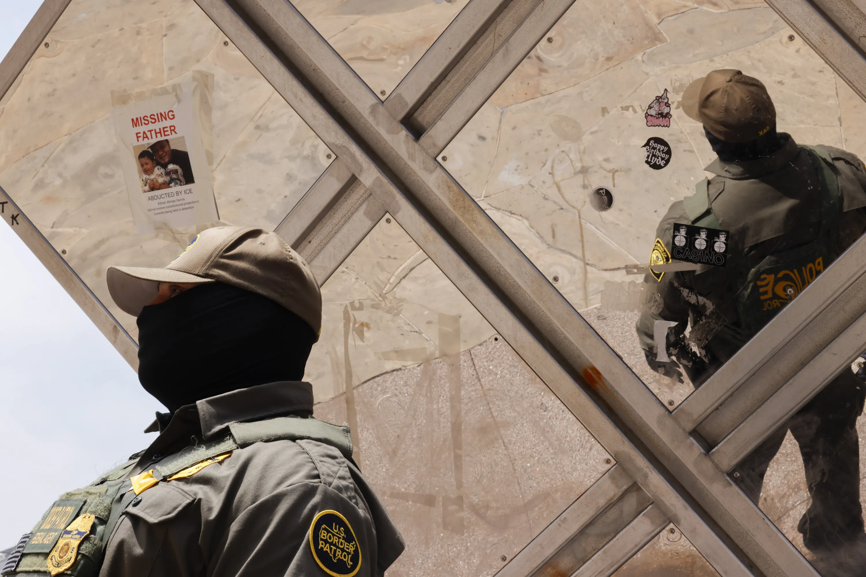 A masked US Border Patrol officer stands watch in downtown Los Angeles in August.&nbsp;