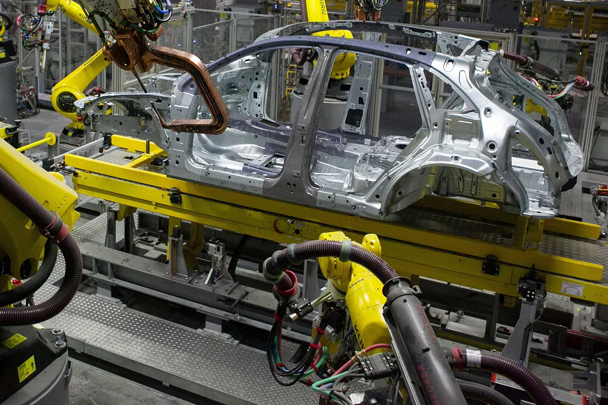 Robotic arms operate on the chassis of Porsche Macan sport-utility vehicles (SUV) inside the new Porsche AG factory in Leipzig, Germany, on Wednesday, Feb. 5, 2014.
