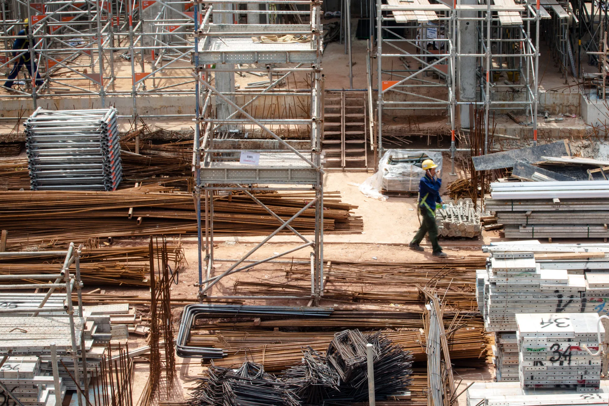 A worker walks near piles of construction materials at the construction site of a residential property development in Singapore, on&nbsp;June 5, 2017.