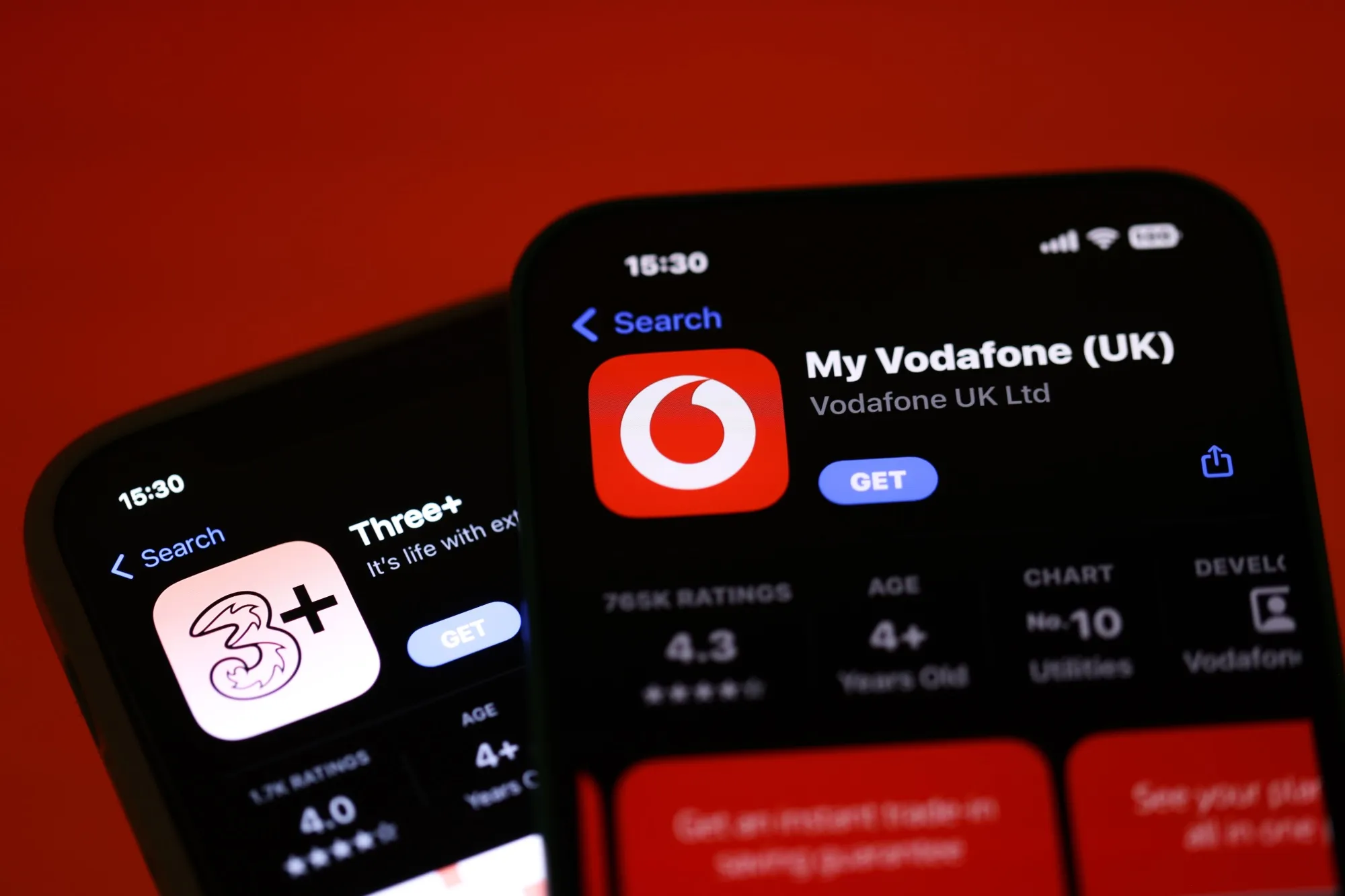 Smartphones displaying the Three UK and the Vodafone Group Plc apps.