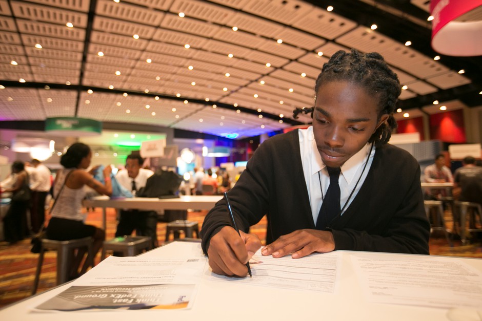 A young man fills out an application at a Chicago job fair. 