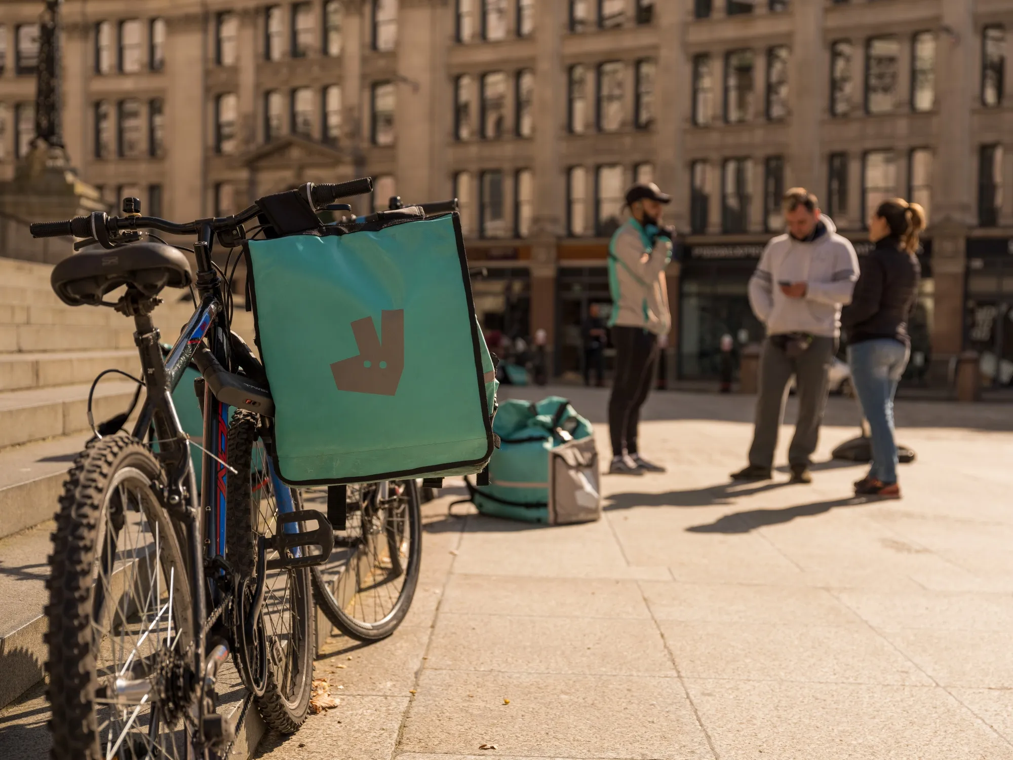 Food delivery couriers carrying Deliveroo bags gather in the City of London on March 24.