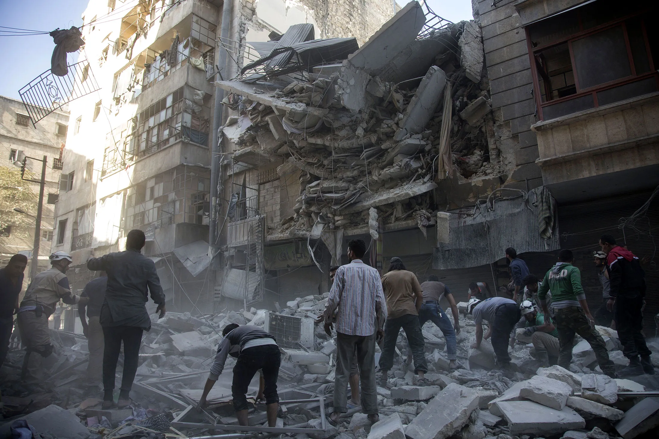 Rescuers gather at site of air strike in the rebel held neighborhood of Al-Shaar in Aleppo on Sept. 27, 2016.
