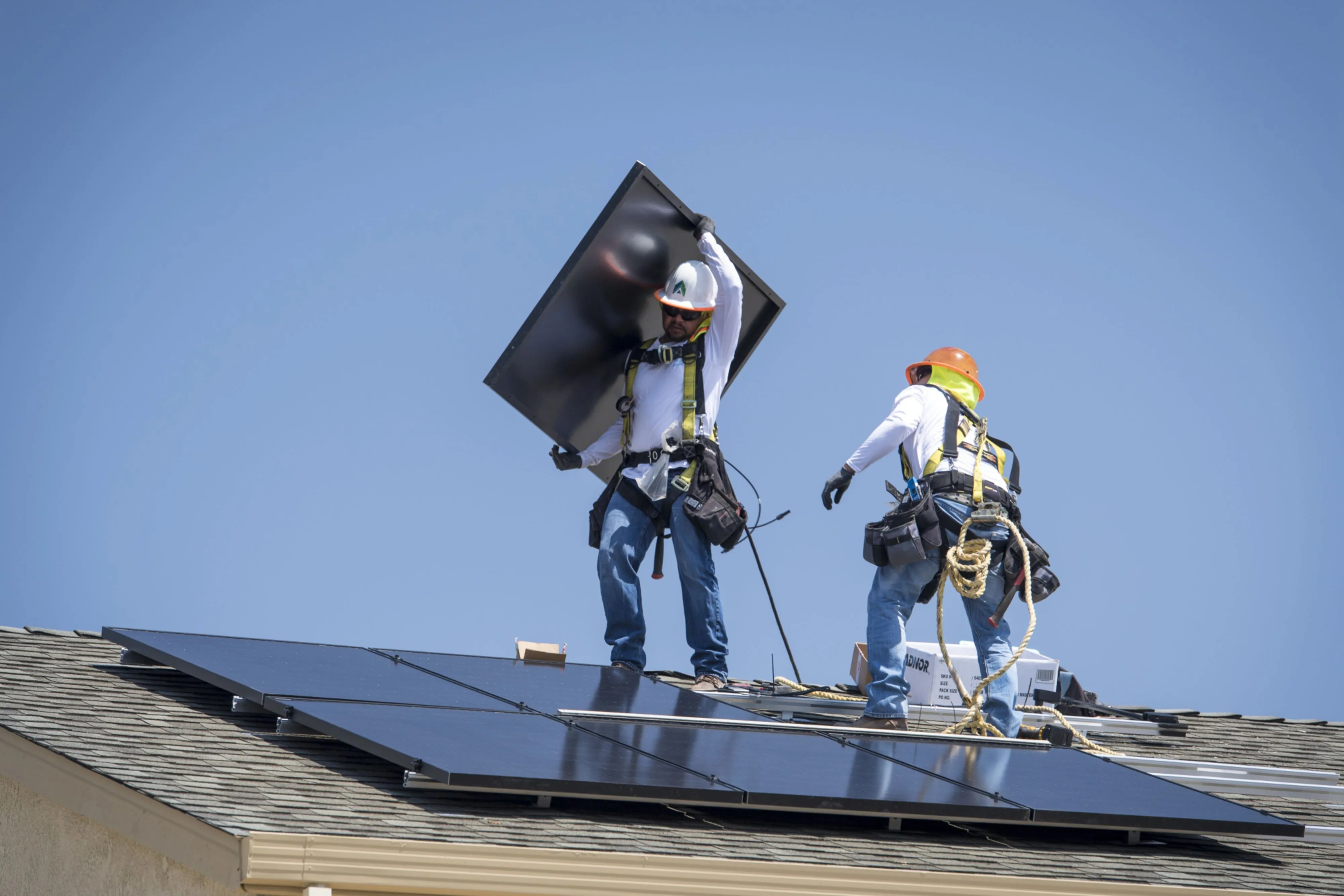 Contractors install&nbsp;solar panels on the roof of a new home in Sacramento, California, in 2018. California is the first state in the U.S. to require solar panels on almost all new homes.