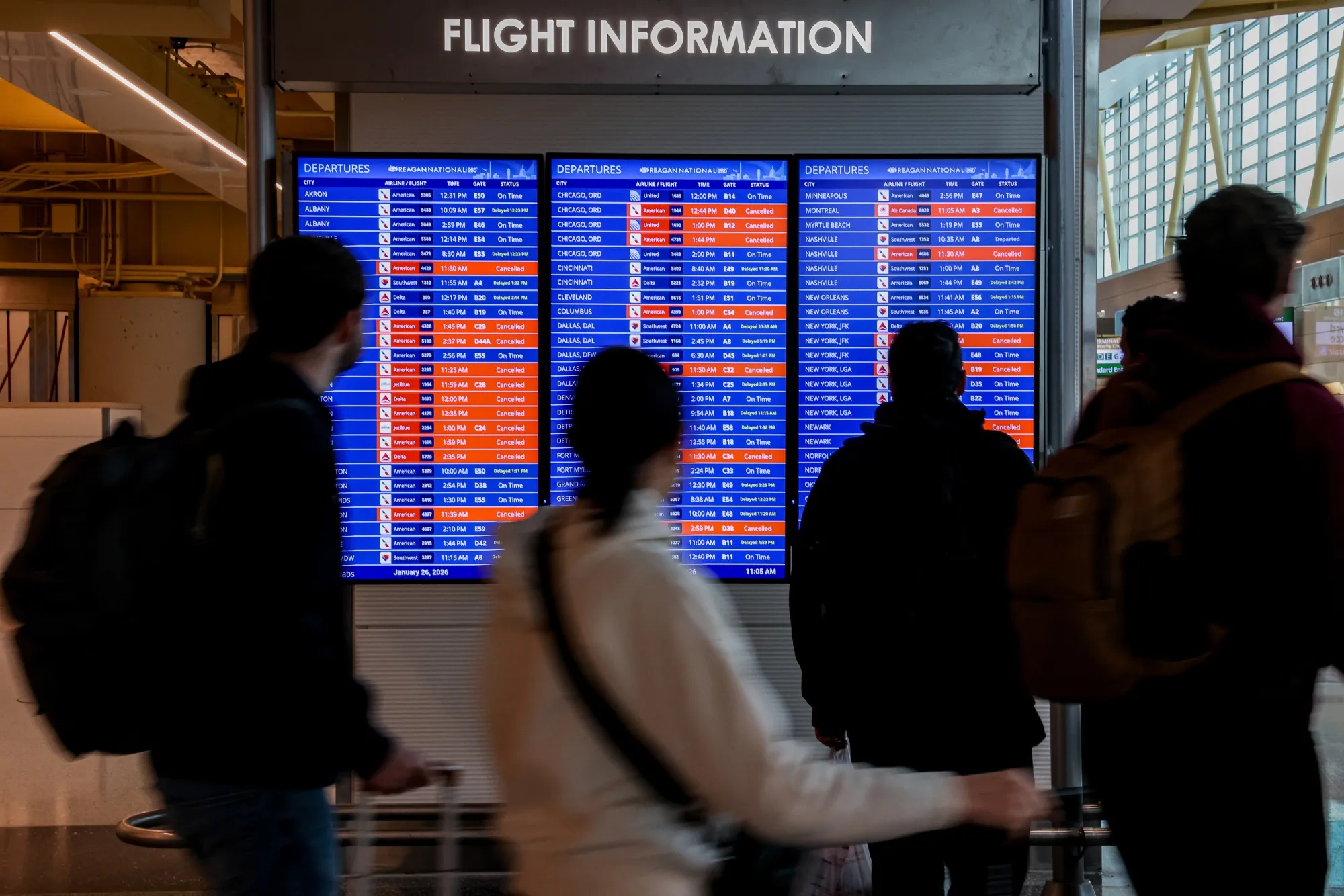 Travelers look at a flight information board at Ronald Reagan Washington National Airport&nbsp;in Arlington, Virginia on Jan. 26.