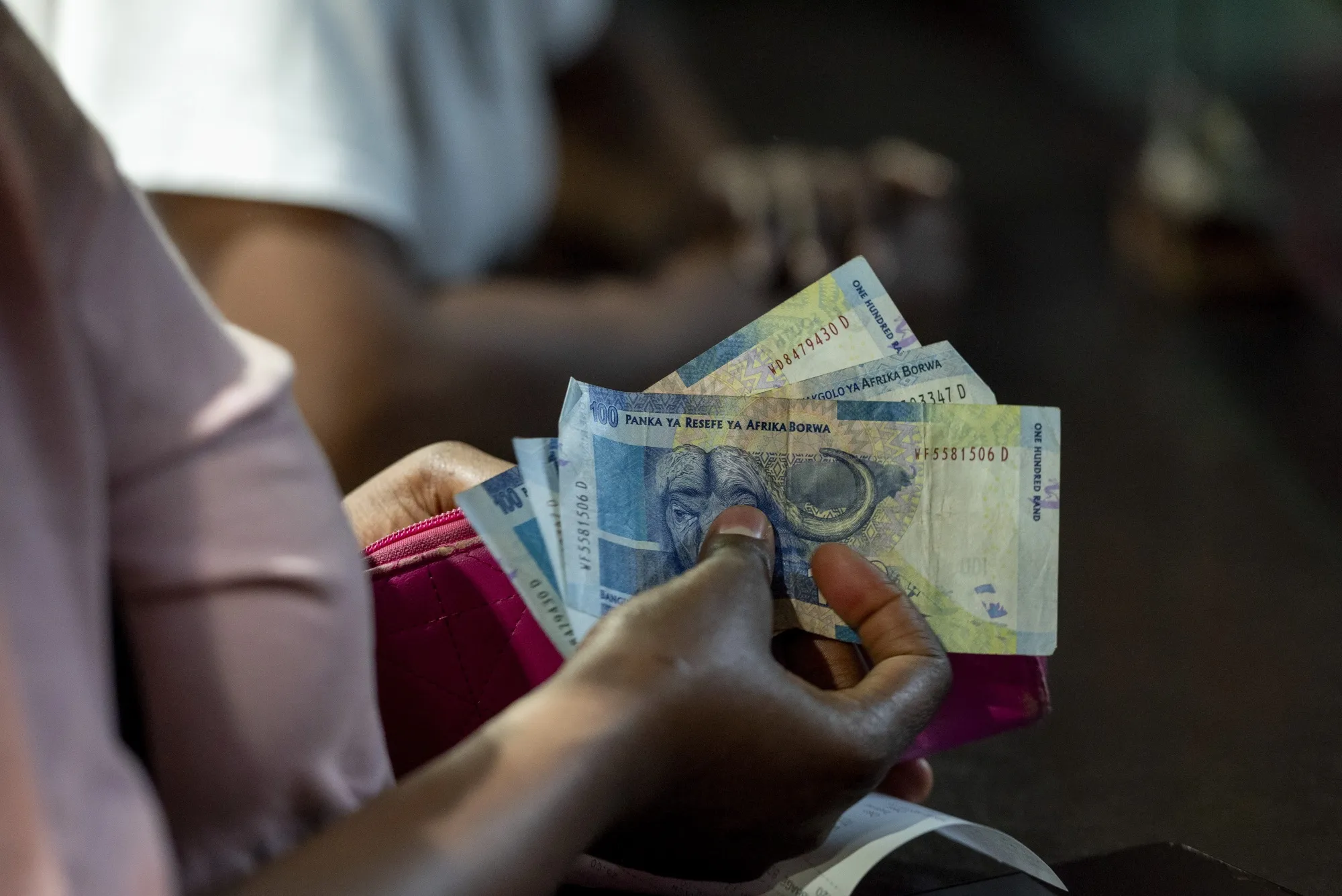 A customer holds rand banknotes at a&nbsp;food market in Johannesburg.