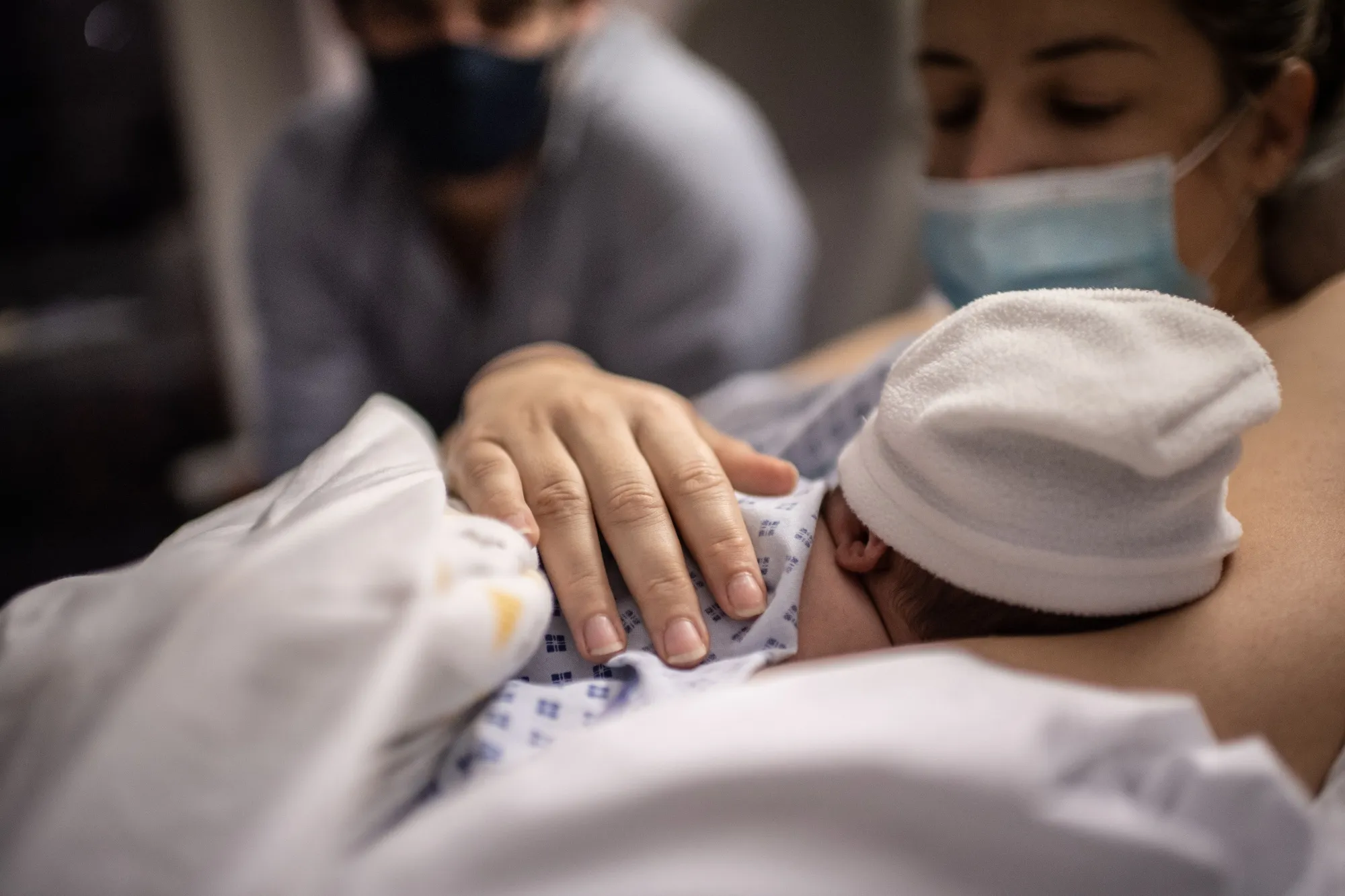 A father and a mother look at their newborn son.&nbsp;