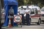 Police officers wearing face masks stand guard at a road block outside a temporary quarantine camp, in Hong Kong, on Jan. 23.