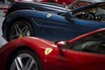A Ferrari California T, back, and 488 GTB sports vehicles sit parked outside of the New York Stock Exchange (NYSE) in New York, U.S., on Wednesday, Oct. 21, 2015. Ferrari NV climbed as much as 17 percent after its initial public offering, the first step in Fiat Chrysler Automobiles NV's plans to spin off the supercar maker to finance expansion plans.
