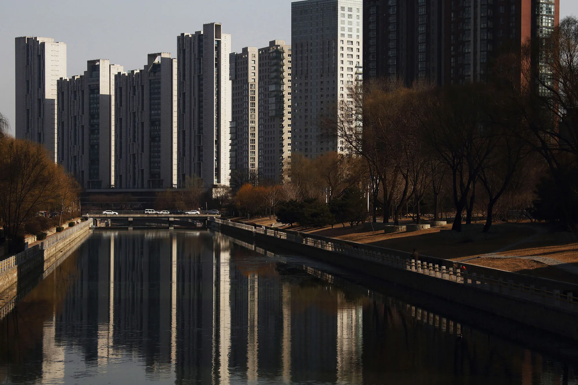 Residential towers are reflected in a river in Beijing, China.
