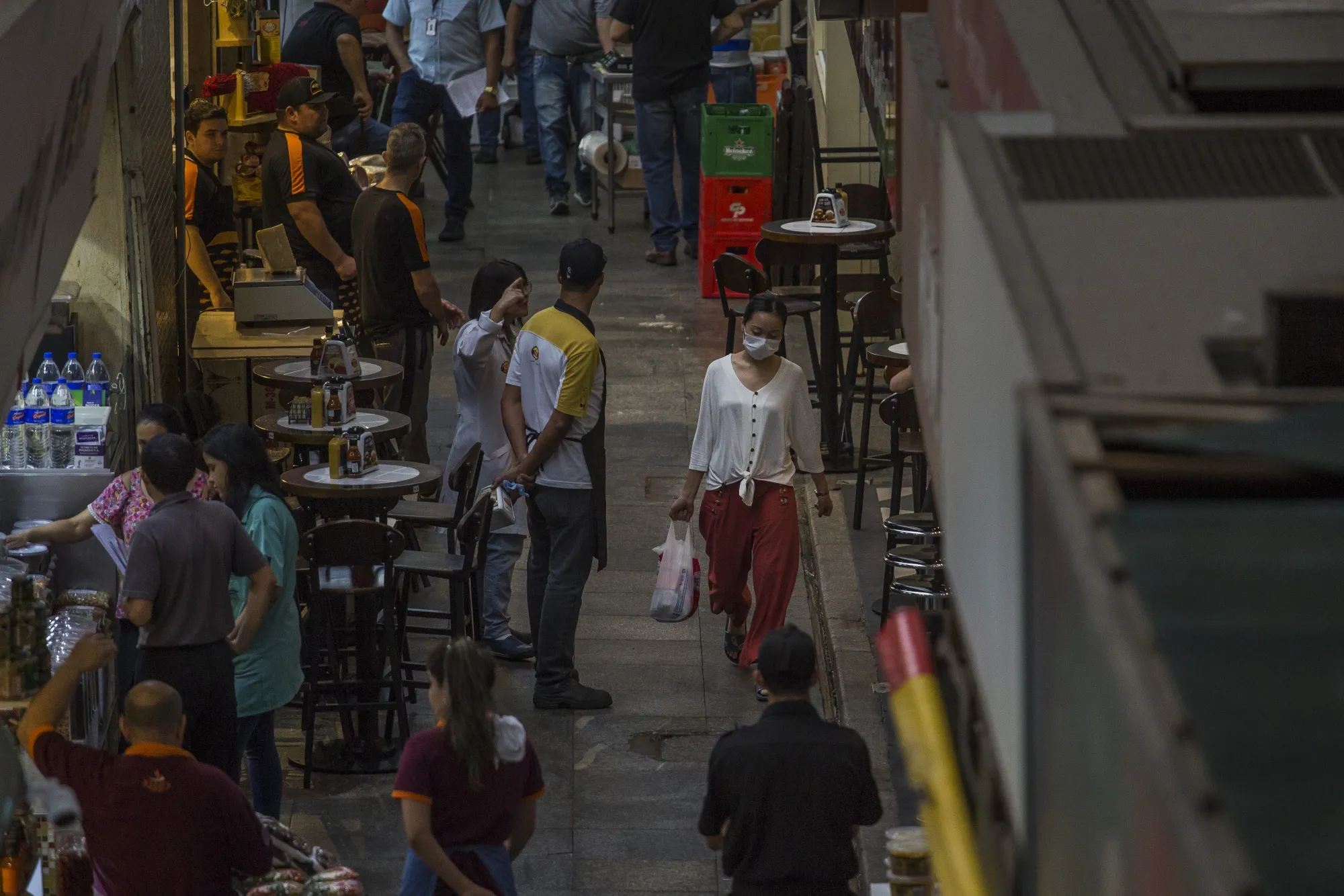 A shopper wearing a protective mask walks through the Municipal Market in Sao Paulo on March 19.