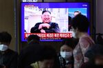 People watch a television broadcast reporting an image of Kim Jong-un during a news program.